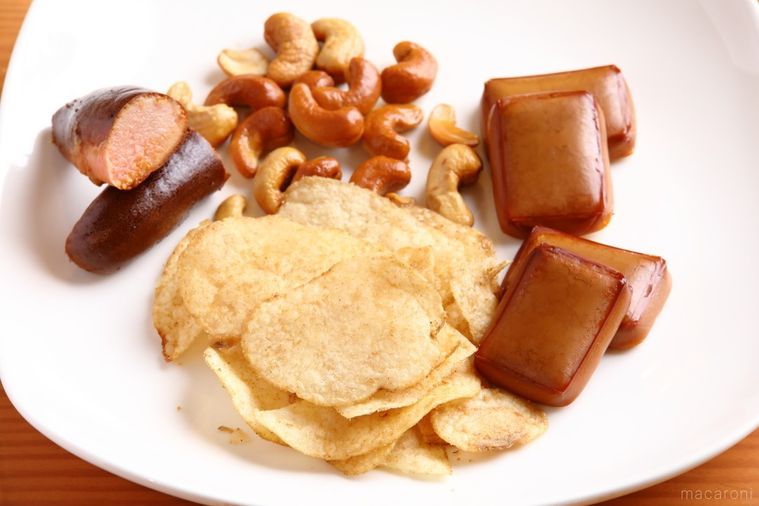 白い皿にのった明太子、ナッツ、チーズ、ポテトチップスの燻製