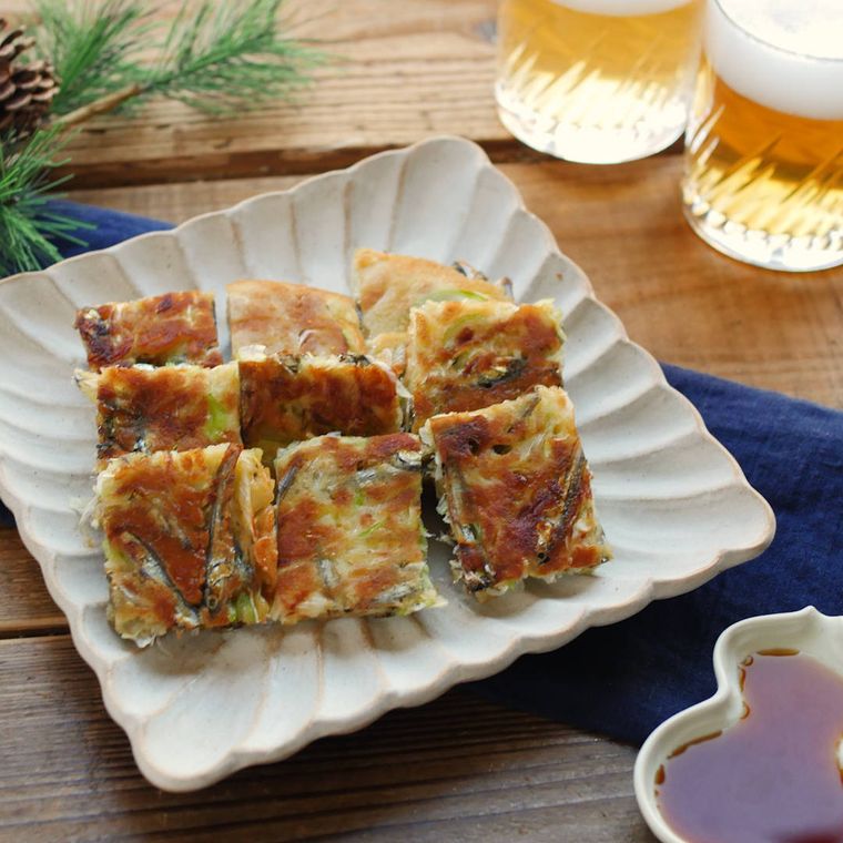 白い皿に盛られたごまめチヂミに、グラスに入ったビールが添えられている様子