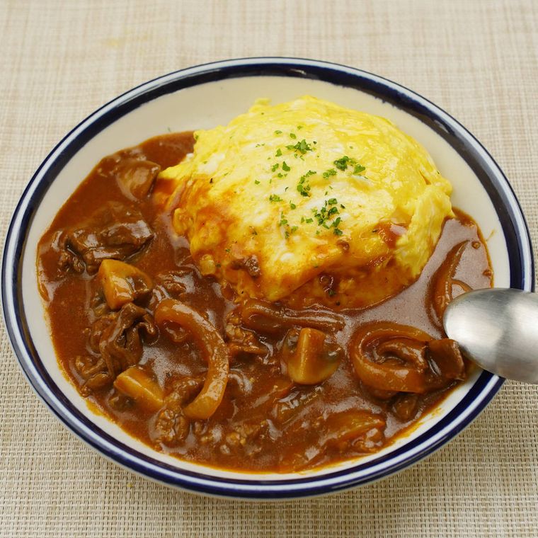 紺色の縁取りがある皿に盛り付けられたふわふわ卵のオムハヤシ