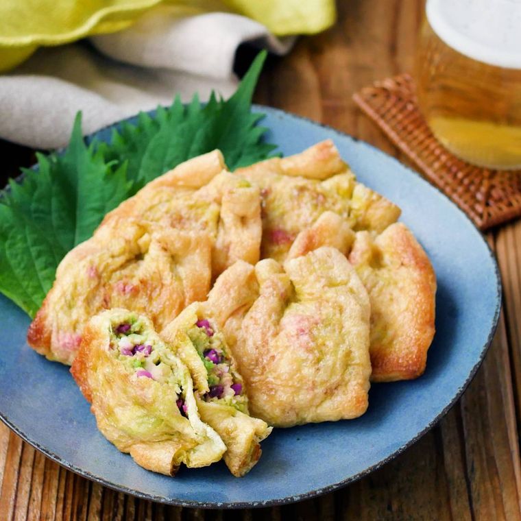 青い皿に盛り付けた、大葉を敷いたアボカドタルタルきつね焼き