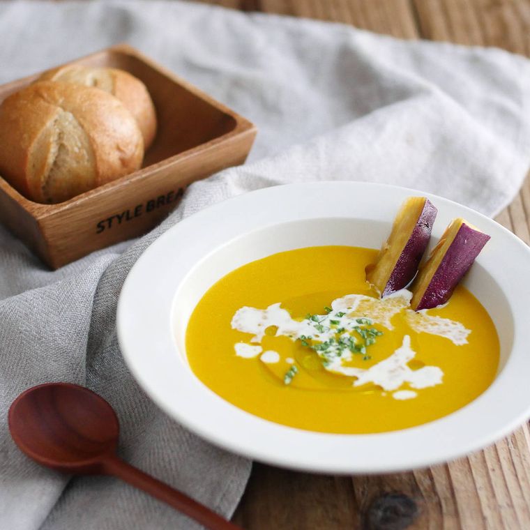 白いスープ皿に盛り付けたさつまいもとかぼちゃのポタージュ