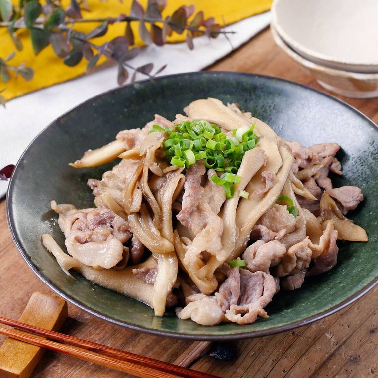 黒い皿に盛り付けた豚こまとまいたけのバター醤油炒め