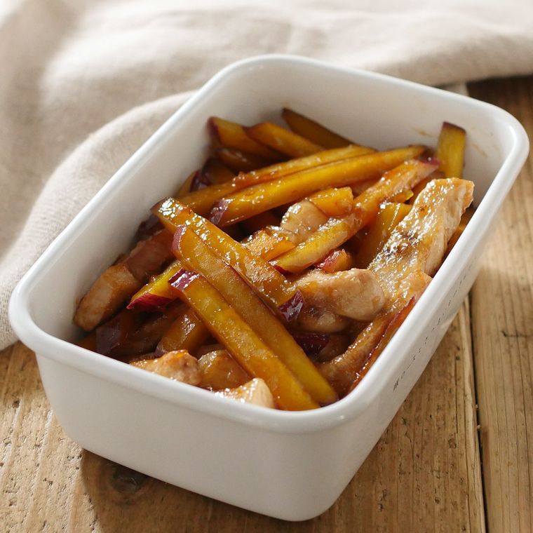 白い保存容器に入った、厚切り豚ロース肉とさつまいものきんぴら