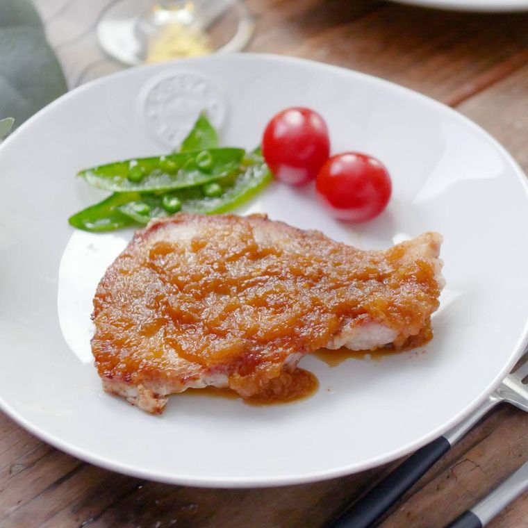 皿に盛りつけられたポークジンジャーとミニトマト、スナップえんどう