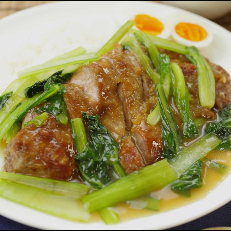 白いプレートに盛り付けた、厚切り豚ロース肉のパイコー飯風