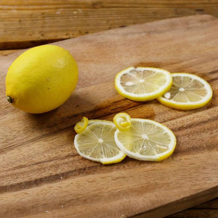 カッティングボードの上でレモンの輪切りを皮結びした様子