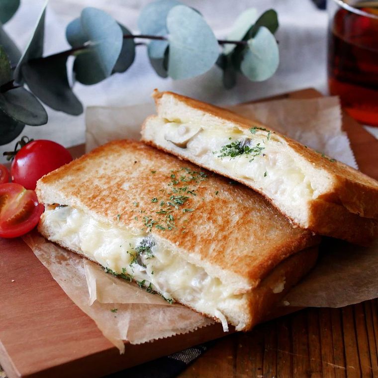 カッティングボードにのった、クリーミーなグラタンのホットサンド