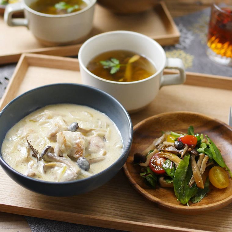 お盆にのったチキンのクリーム煮、きのことトマトのサラダ、コンソメスープ