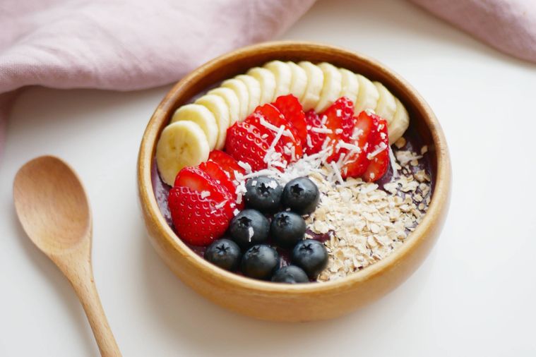 木の器に入ったアサイーボウルに木のスプーンが添えられている