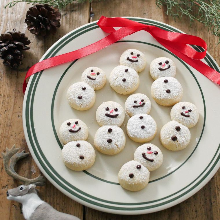 皿の売れに並んだ雪だるまのスノーボールクッキー