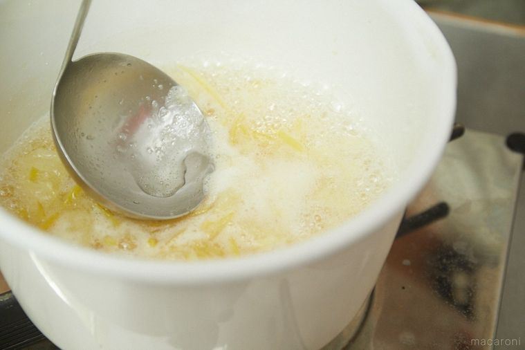 白いホーロー鍋で煮ている最中におたまであくを取る様子