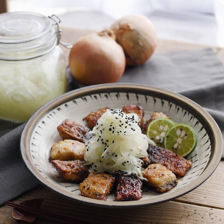茶色い丸皿に盛り付けた、焼きさばの発酵玉ねぎのせ