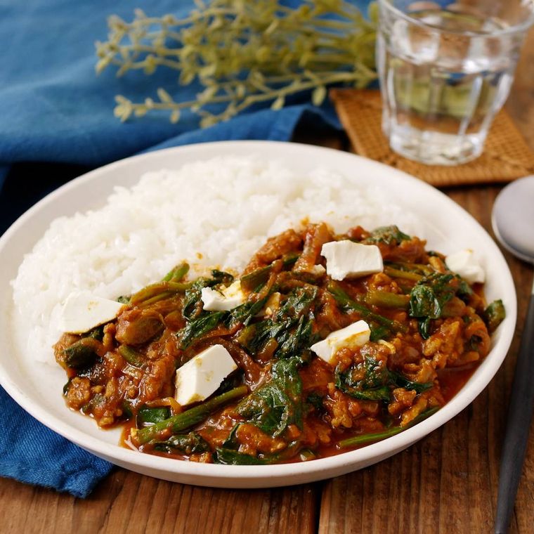白いプレートに盛りつけられたほうれん草とひき肉のカレー