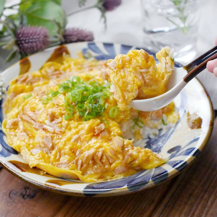 器に盛られたツナたま丼をスプーンですくっている様子