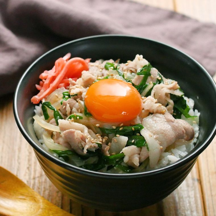 黒い丼に盛られた豚肉のすき焼き丼