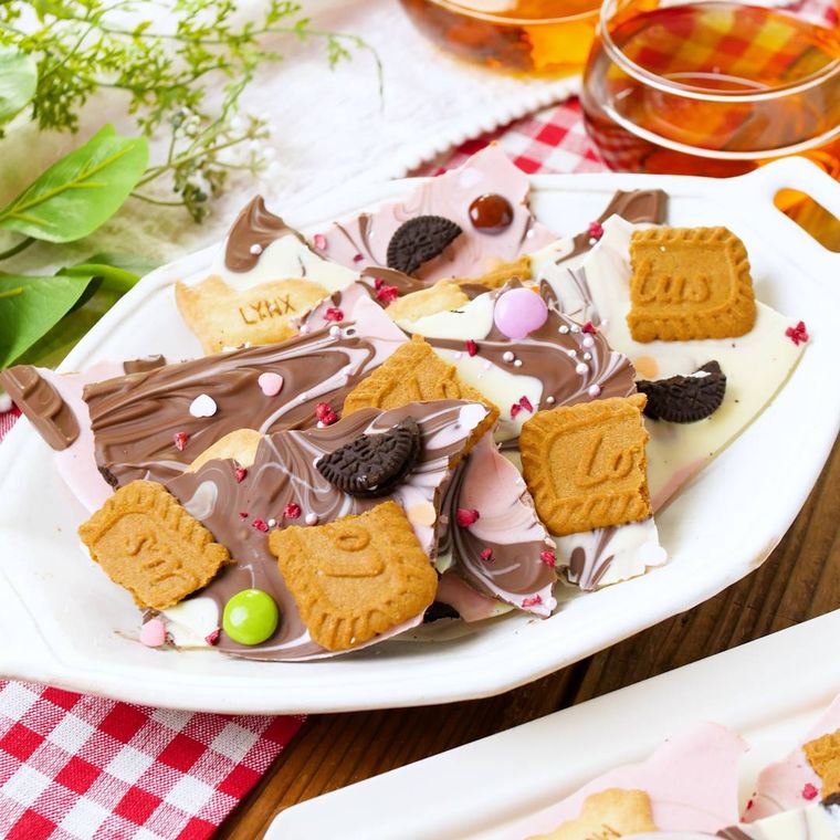 白い皿にデコレーションした板チョコやビスケットなど