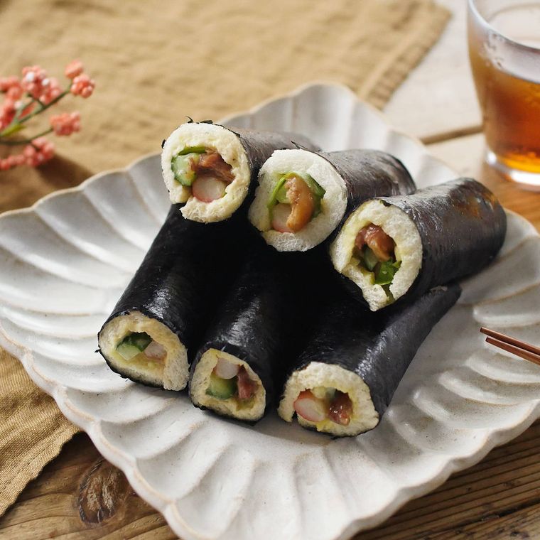 白い角皿に盛りつけられた焼き鳥缶とカニかま入りのロールサンド