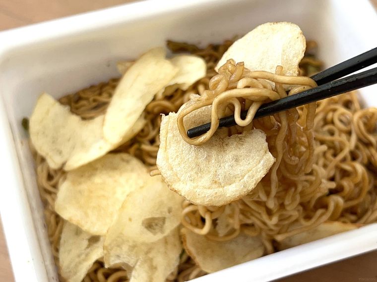 ポテトチップスをかけたぺヤングの麺を箸で持ち上げているところ