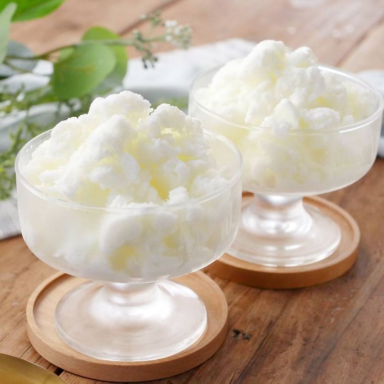 木のコースターにアイスクリームグラスに盛りつけられたカルピスかき氷