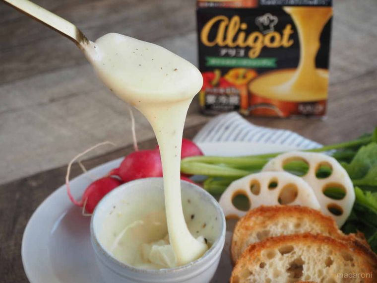 スプーンから流れるチーズとバゲットやサラダ