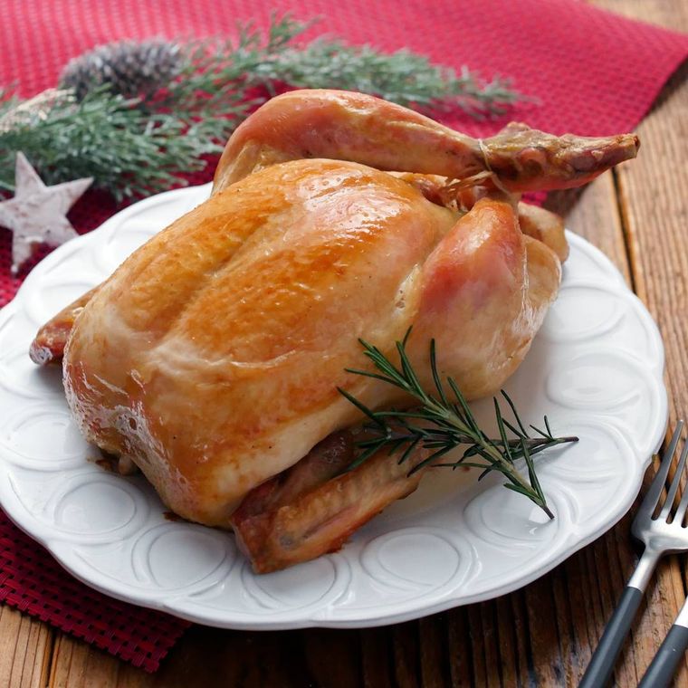 白いプレートに盛り付けられた丸鶏のローストチキン