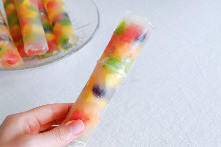 冷凍フルーツ寒天スティックを袋から押し出して手で持つ様子