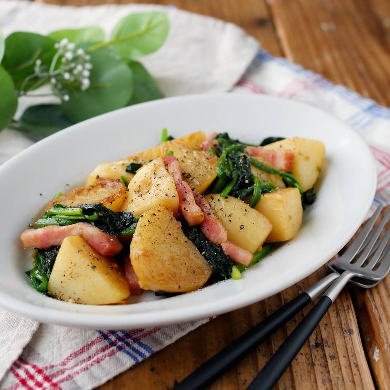 白い皿に盛りつけられたほうれん草とじゃがいものガリバタ炒め