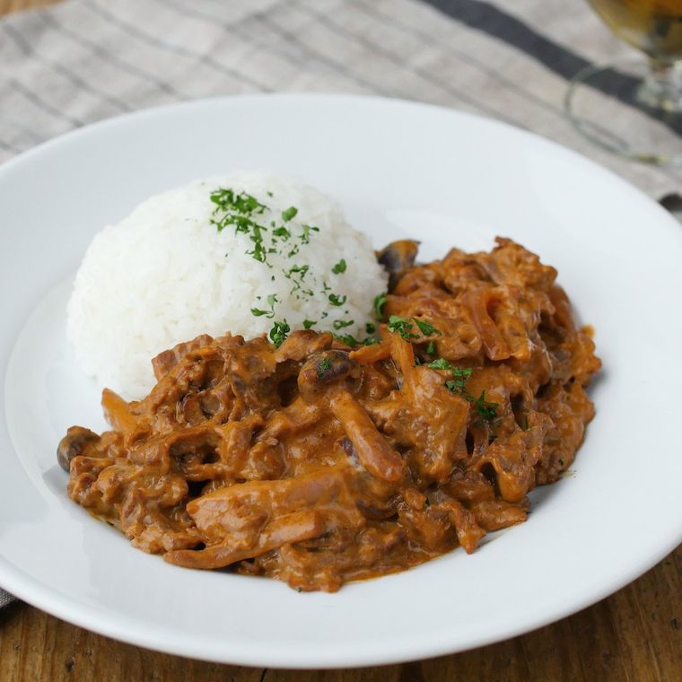 白い皿に盛られたすき焼き肉のビーフストロガノフ