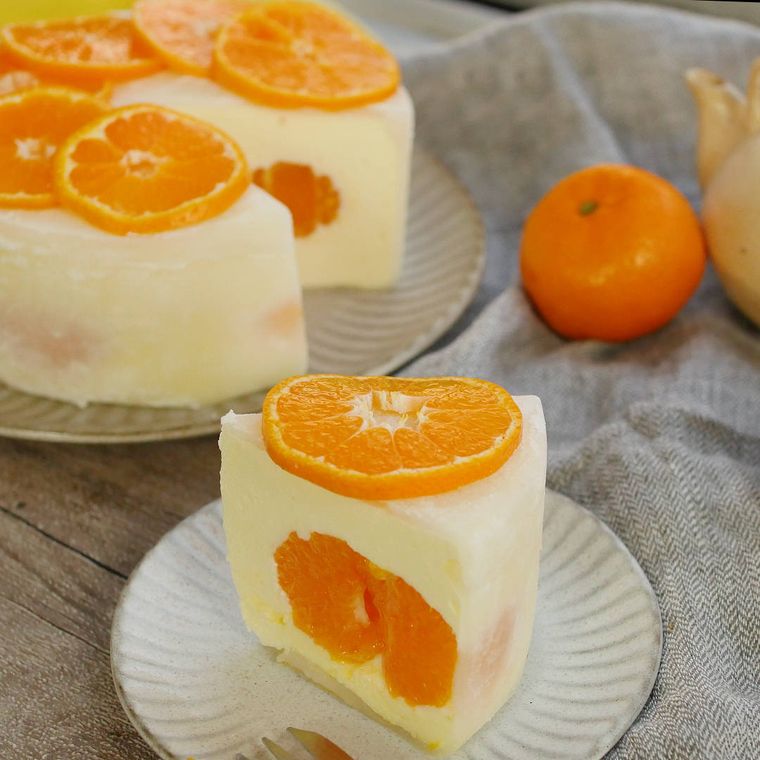 カットして白い皿に盛られた、みかんのチーズムースケーキ