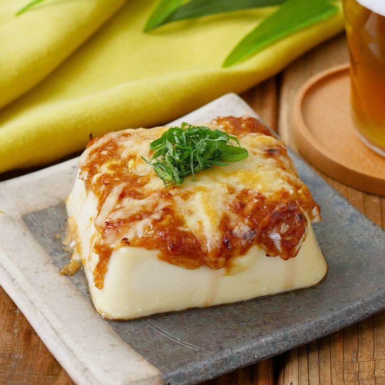 グレーの皿にのっている豆腐のねぎみそチーズ焼き