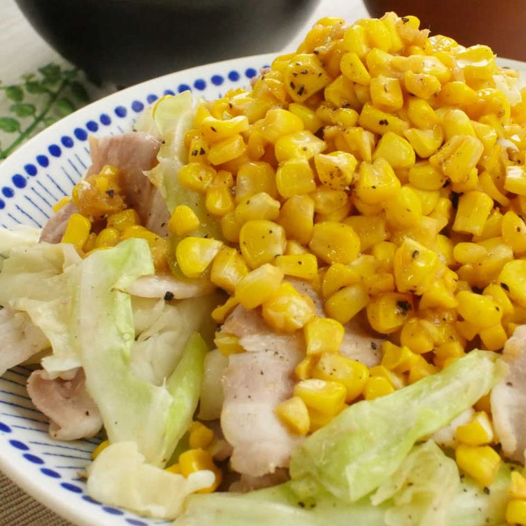 白に青いドット模様が入った皿に盛り付けた、豚肉とキャベツの味噌バターコーン蒸し