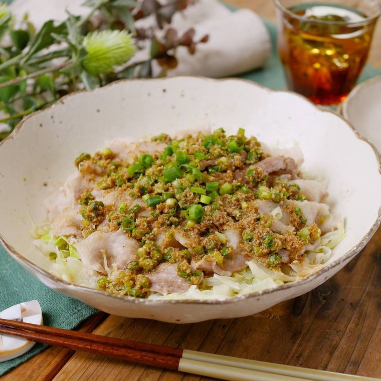 白い皿に盛り付けた千切りキャベツと豚バラ肉のレンジ蒸しとお茶