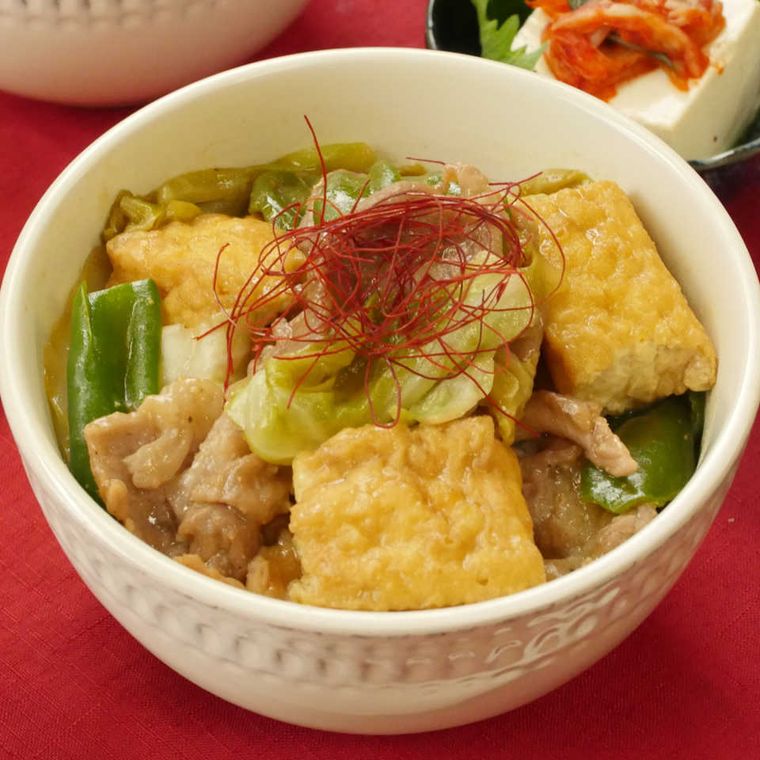 白い丼鉢に盛りつけられた豚こま肉と厚揚げのオイスターソース丼