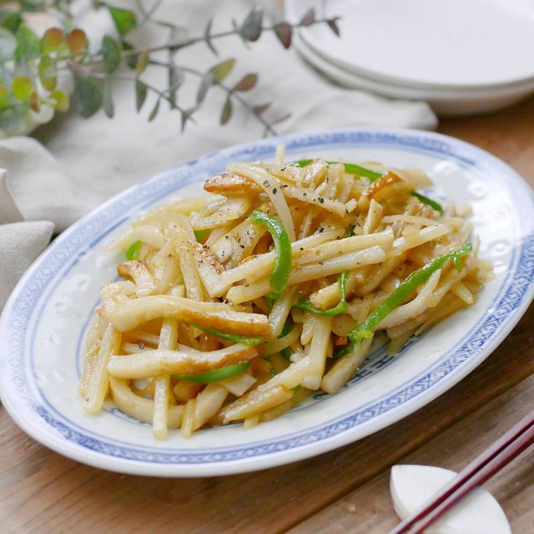 縁取りのある皿に盛りつけたちくわとピーマン、ポテトの中華炒め