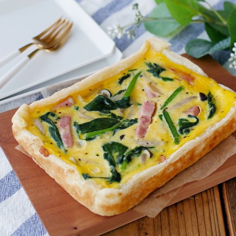 カッティングボードに盛りつけられた卵焼き器形の手軽なキッシュ