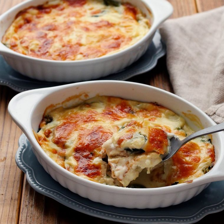 ツナ缶とほうれん草の豆腐グラタンをスプーンですくっている様子