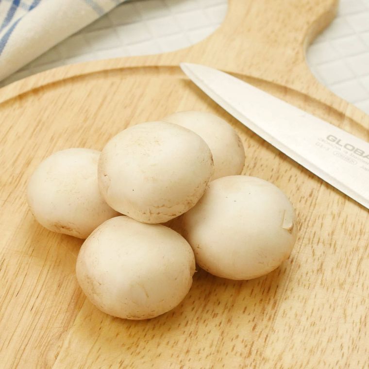 カッティングボードの上で石づきを切り落としたマッシュルーム