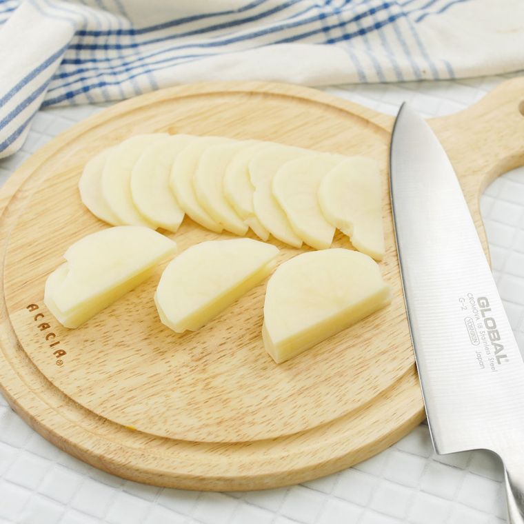 カッティングボードの上で半月切りされたじゃがいも