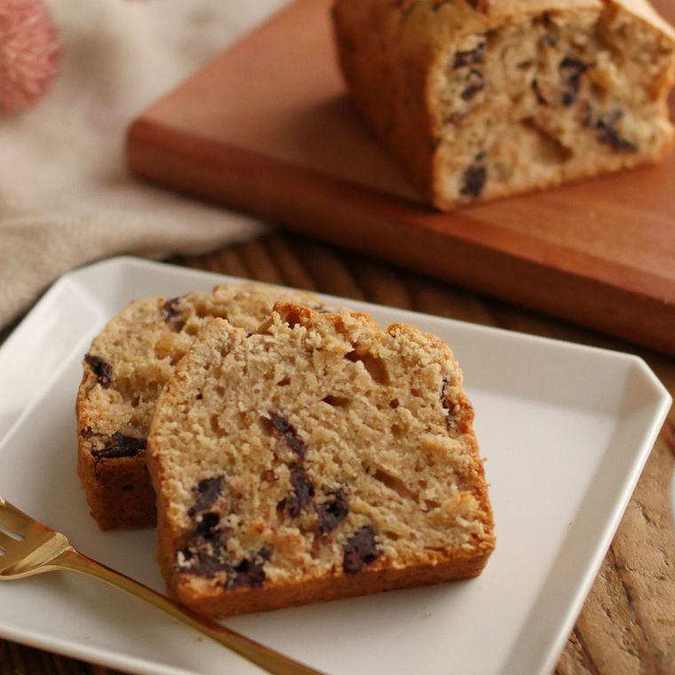 白い皿に盛られた、2切れのチョコバナナケーキと、木のプレートに置かれたチョコバナナケーキ