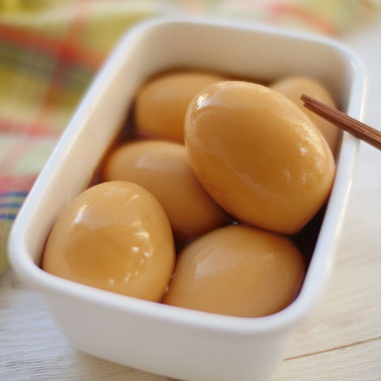 白い保存容器に入っている酢じょうゆの味卵