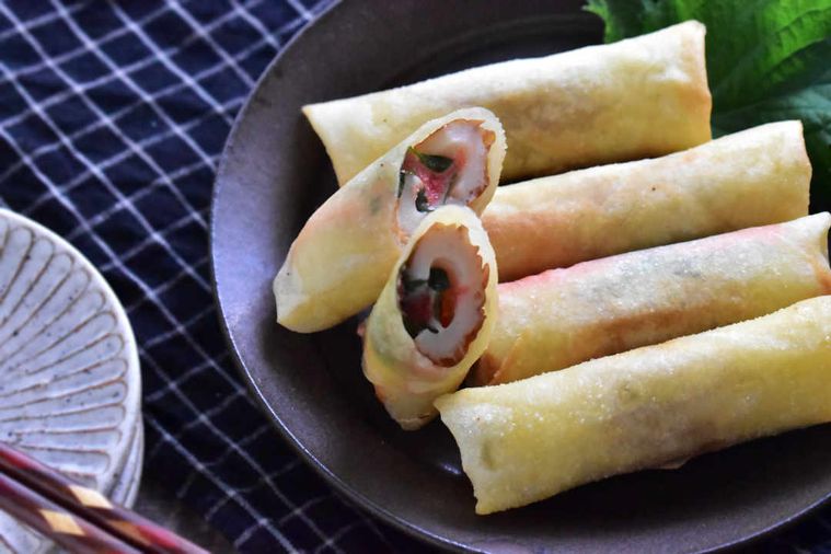 黒い皿に乗ったちくわと明太チーズの春巻き