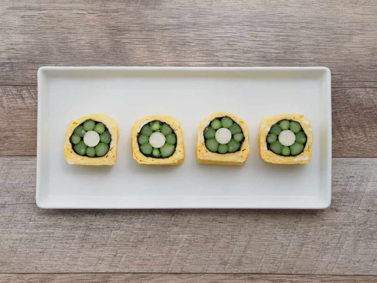 長方形の白い皿にのったアスパラガスのお花卵焼き