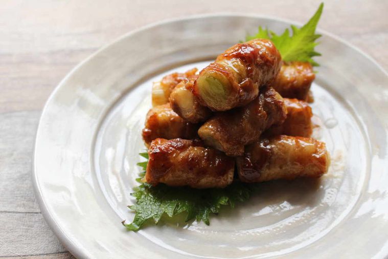 丸くて白いお皿に乗った長ねぎの肉巻き