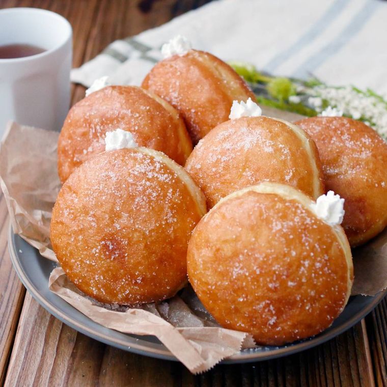 黒い皿にたくさん並べられた、ふわふわクリームドーナツ