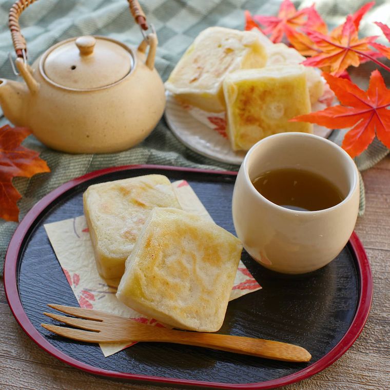 黒いトレーにお茶と一緒に盛られた、クリームチーズのさつまいもきんつば