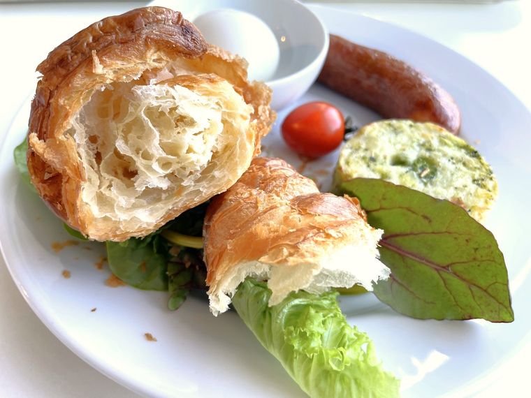 2つにちぎり分けたクロワッサンが載ったプレートをななめ前から撮影