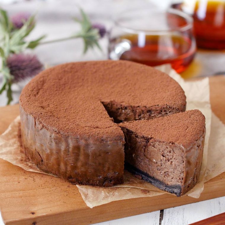 木製のカッティングボードに置かれたチョコレートチーズケーキ