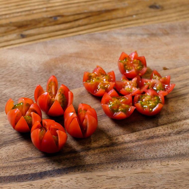 ミニトマトの飾り切りがまな板のうえにのっている様子