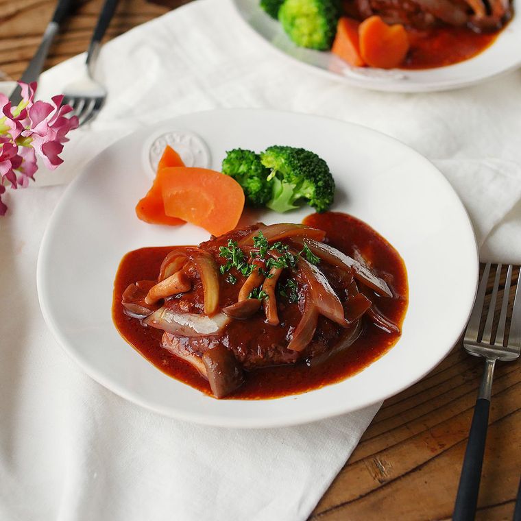 白い皿に盛られている煮込みハンバーグ