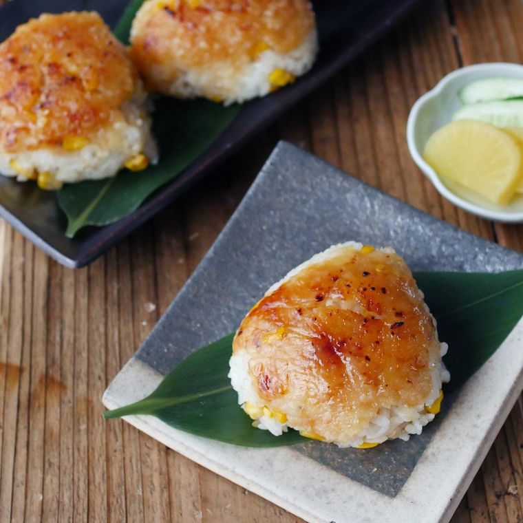 白色と黒色の四角の皿におかれたみそバターコーン焼きおにぎり